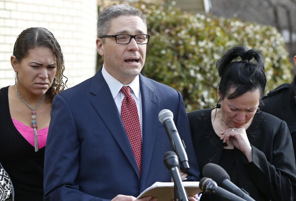 Attorney Michael Brooks-Jimenez, center, speaks at a news conference as Nair Rodriguez, right, and Francheska Medinain, listen, in Oklahoma City, Tuesday, Feb. 25, 2014. The family of Luis Rodriguez, who died after a struggle with police outside an Oklahoma movie theater, released a cellphone video Tuesday, which shows five officers restraining the man face-down on the ground, with one officer holding his head down. (AP Photo/Sue Ogrocki)