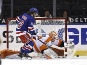 New York Rangers' Artemi Panarin (10) heads for the net as Philadelphia Flyers' Brian Elliott (37) defends in the first period of an NHL hockey game Thursday, April 22, 2021, in New York. (Elsa/Pool Photo via AP)