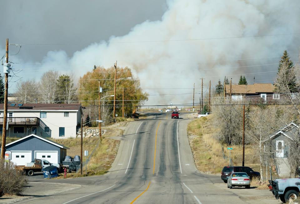 Smoke from wildfires rises in the background, Thursday, Oct. 22, near Granby, Colorado.