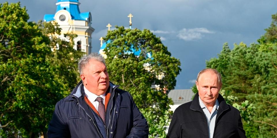 Russian President Vladimir Putin, right, and Russian CEO of Rosneft oil company Igor Sechin seen with the Konevsky Monastery on the Lake Ladoga behind them, Saturday, July 31, 2021.