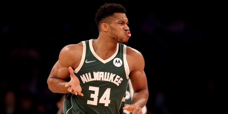 Giannis Antetokounmpo celebrates and holds up his hand during a game.