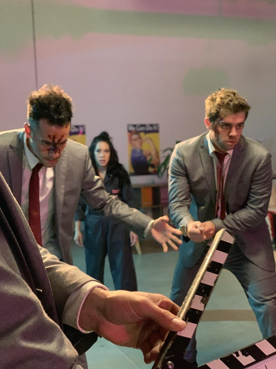 actors handcuffed together with stage blood on faces