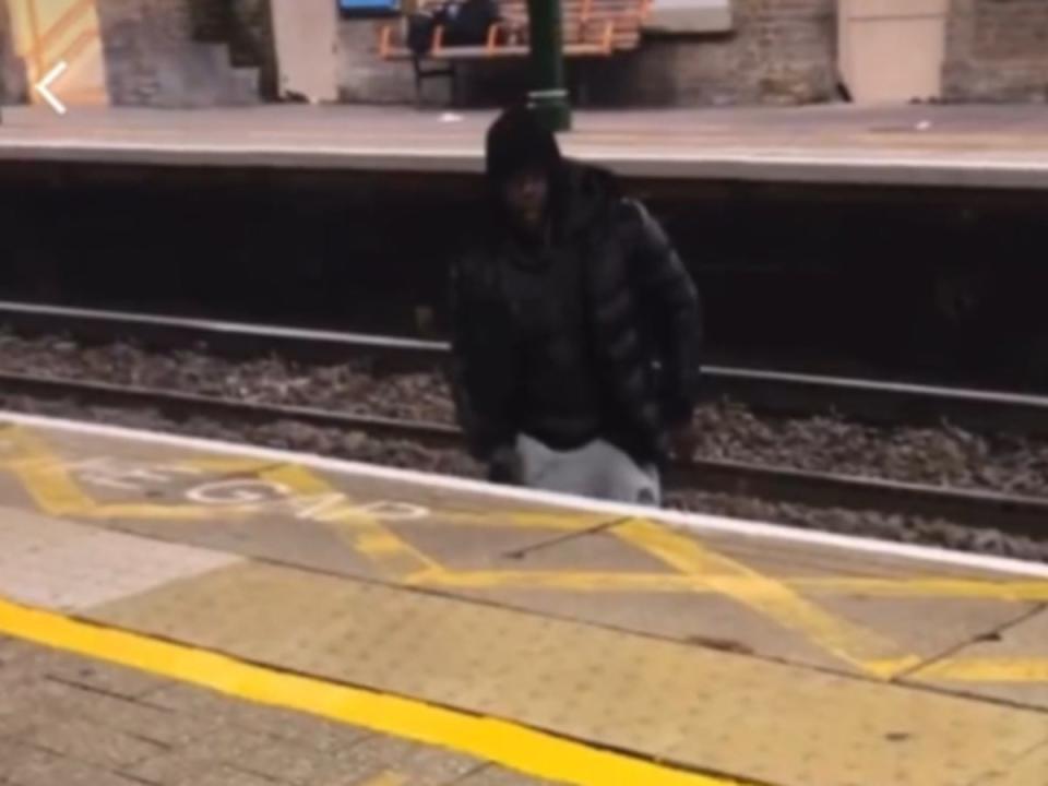 A viral video shows a man jumping over the train tracks to harass a woman (Twitter)