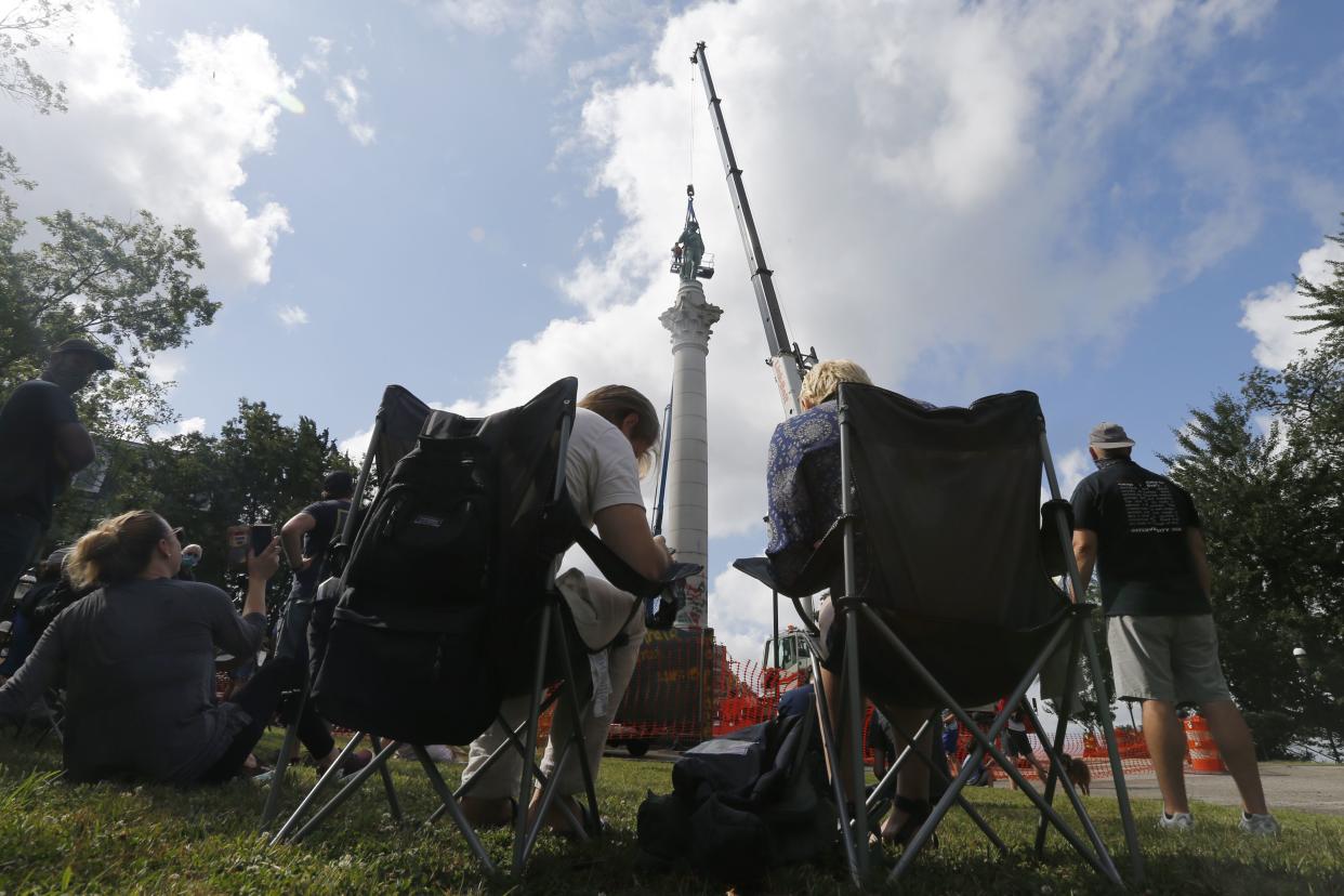 Spectators watch as crews work to remove the Confederate Soldiers & Sailors Monument in Libby Hill Park on July 8, 2020.