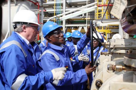 Ghana's President John Atta Mills turns on the valve to allow the first barrel of crude to flow from the Jubilee offshore oil field, December 15, 2010. REUTERS/Courtesy of CTM Communications/Tullow Oil/Handout