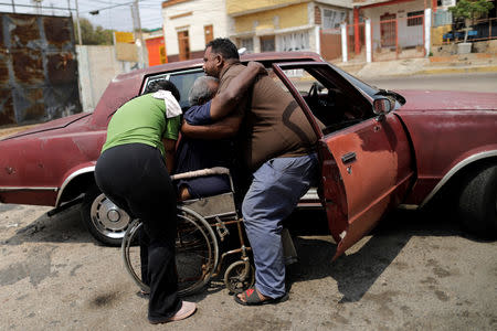FILE PHOTO: Elimenes Fuenmayor, 65, who has kidney disease, is helped by his sons, as he leaves his house to go to the dialysis centre, during a blackout in Maracaibo, Venezuela April 11, 2019. REUTERS/Ueslei Marcelino
