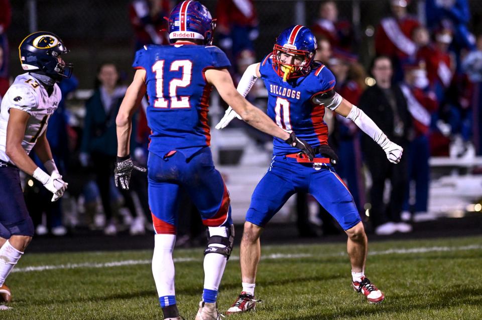 Mason's Cole Ries, right, celebrates with Tyler Baker, left, after Ries broke up a pass in the end zone during the third quarter in the game against DeWitt on Friday, Nov. 3, 2023, at Mason High School.