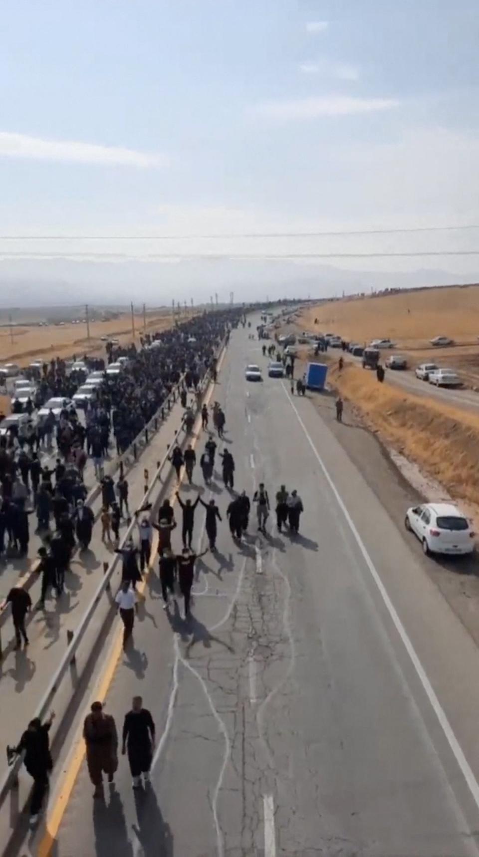 People march down the highway toward the Aychi Cemetery (VIDEO OBTAINED BY REUTERS)