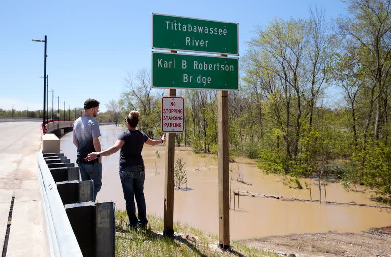 Residents look at flood waters along the Tittabawassee River, after several dams breached, in downtown Midland