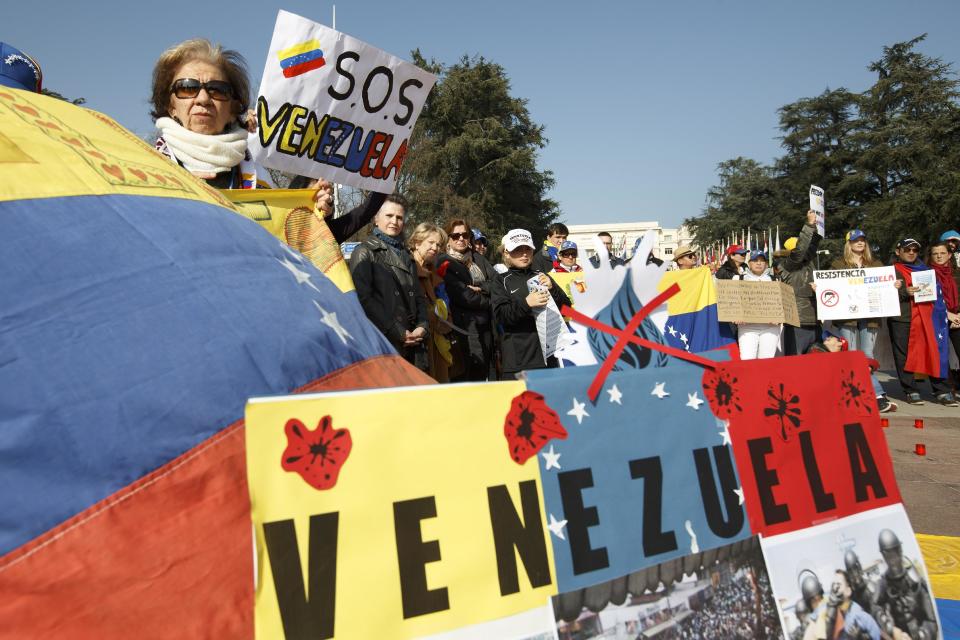 Protesters hold posters and banners, during a rally against the Venezuela's government on the Place des Nations in front of the European headquarters of the United Nations, in Geneva, Switzerland, Saturday, March 8, 2014. (AP Photo/Keystone,Salvatore Di Nolfi)