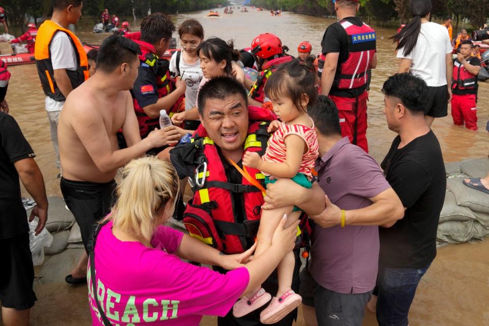 Rescuers using rubber boats to evacuate children through floodwaters in Zhuozhou in northern China's Hebei province in August (Copyright 2023 The Associated Press. All rights reserved)