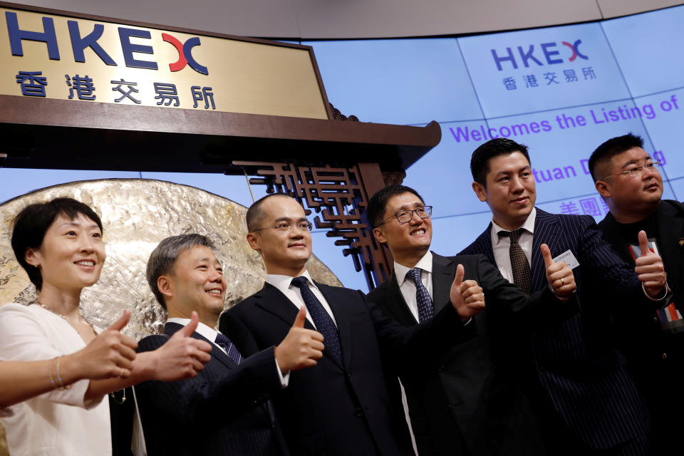 Wang Xing (3rd L), co-founder, chairman and chief executive officer of China's Meituan Dianping, attends the debut of the company at the Hong Kong Exchanges in Hong Kong, China, September 20, 2018. REUTERS/Tyrone Siu