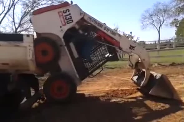 Digger drives on two wheels onto lorry flat-bed