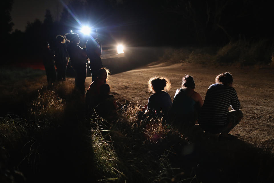 A U.S. Border Patrol vehicle illuminates a group of Central American asylum-seekers before taking them into custody near the U.S.-Mexico border on June 12, 2018, in McAllen, Texas. The group of women and children had rafted across the Rio Grande from Mexico and were detained by U.S. Border Patrol agents before being sent to a processing center for possible prosecution and separation. (Photo: John Moore via Getty Images)