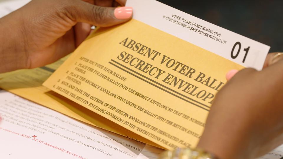 An attendee at a Detroit election worker training reviews the stub number attached to a sample absentee ballot ahead of Aug. 2, 2022 primary.