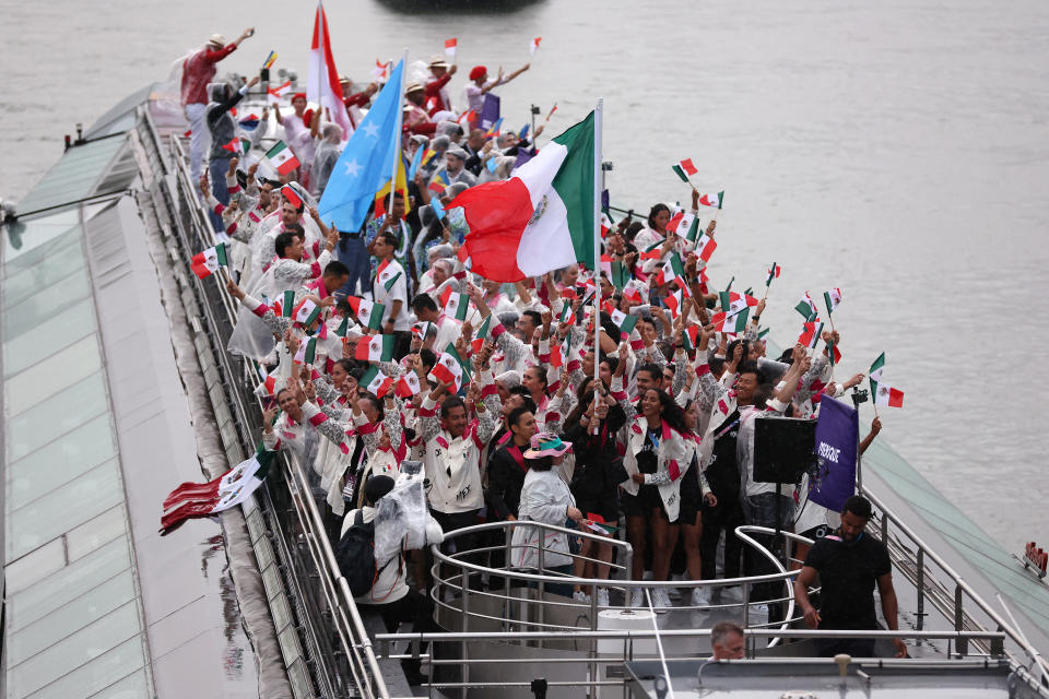 PARIS, FRANCE - JULY 26: Emiliano Hernandez and Alejandra Orozco Loza, Flagbearers of Team Mexico, are seen on a boat waving their flag along the River Seine during the opening ceremony of the Olympic Games Paris 2024 on July 26, 2024 in Paris, France. (Photo by Lars Baron/Getty Images)