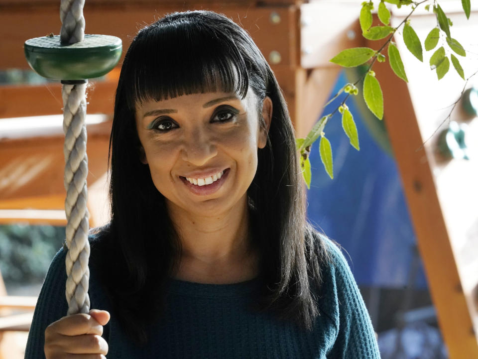 Mary De La Rosa holds onto a swing rope in her home backyard that once housed the now-closed child care program, Creative Explorers, Wednesday, Oct. 21, 2020, in Los Angeles. When De La Rosa closed her toddler and preschool program in March because of the coronavirus pandemic, she fully expected to serve the children again some day. In the end, though, Creative Explorers closed for good. The story of De La Rosa’s program is being repeated across the country as the pandemic’s effects ripple through child care, disproportionately affecting Black and Latino-owned centers in an industry that has long relied on providers of color. (AP Photo/Damian Dovarganes)