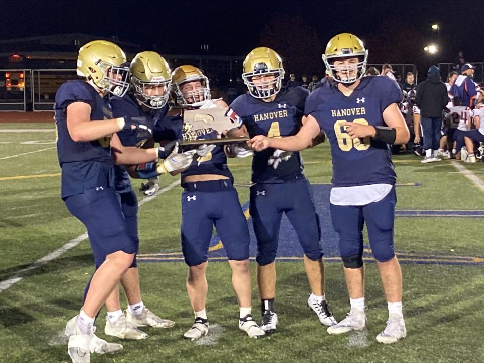 Hanover's five senior captains -- Ben Hickey, David Quinlan, Joe Curran, Nick Freel and Shane Coleman -- celebrate with the Division 3 Final Four trophy after the Hawks beat Walpole, 40-37, in the quarterfinals on Thursday, Nov. 10, 2022.