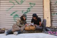 A Free Syrian Army fighter writes on a notebook as he sits with his fellow fighter in the rebel-held al-Myassar neighbourhood of Aleppo, Syria, September 27, 2016. REUTERS/Abdalrhman Ismail