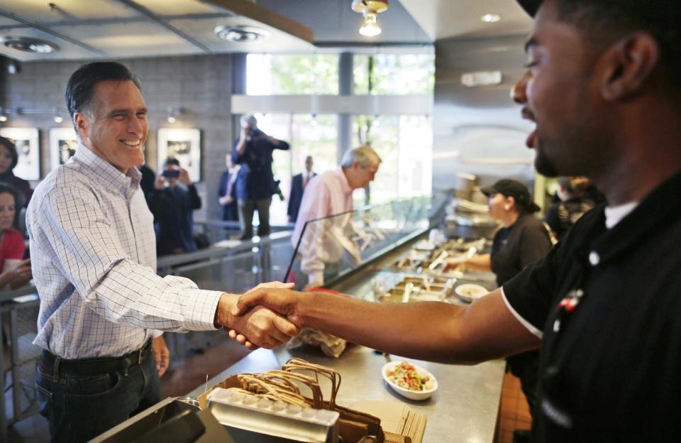 Republican presidential candidate, former Massachusetts Gov. Mitt Romney, accompanied by Sen. Rob Portman, R-Ohio, shakes hands with a worker as he makes an unscheduled stop at a Chipotle restaurant in Denver, Tuesday, Oct. 2, 2012. (AP Photo/Charles Dharapak)