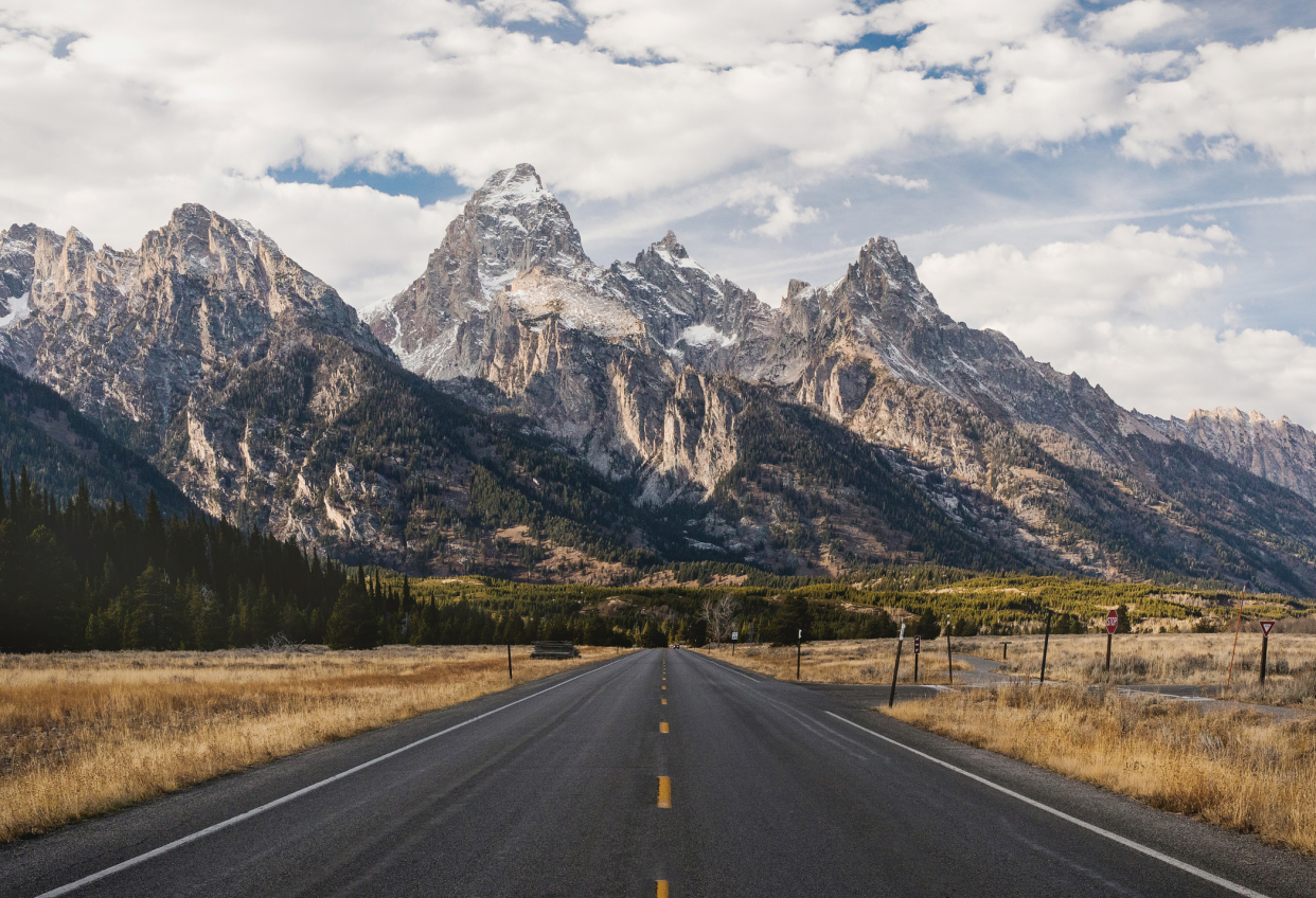 Empty Road Leading Towards Mountains Against Sky, Grand Teton, Wyoming