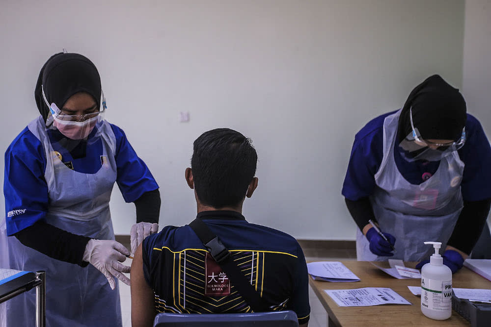 A healthcare worker administers a dose of the Pfizer-BioNTech Covid-19 vaccine to a frontliner at the UiTM Private Specialist Centre in Sungai Buloh March 2, 2021. ― Picture by Hari Anggara