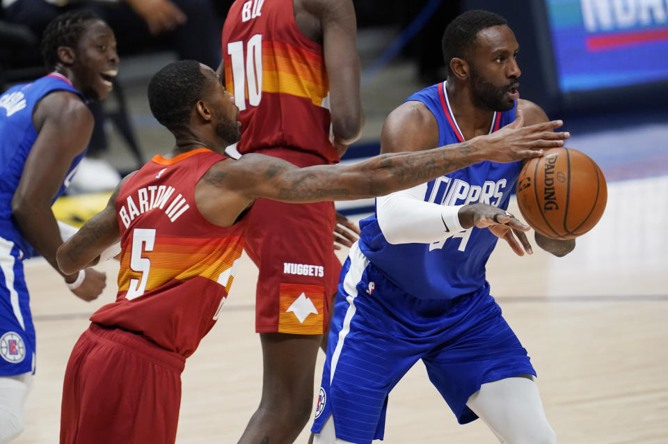 Denver Nuggets forward Will Barton, left, tries to block a pass by Los Angeles Clippers forward Patrick Patterson during the first half of an NBA basketball game Friday, Dec. 25, 2020, in Denver. (AP Photo/David Zalubowski)