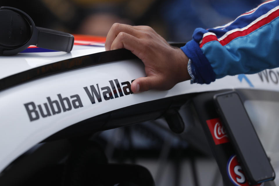 Driver Bubba Wallace leans on his car in the pits of the Talladega Superspeedway prior to the start of the NASCAR Cup Series auto race at the Talladega Superspeedway in Talladega Ala., Monday June 22, 2020. (AP Photo/John Bazemore)