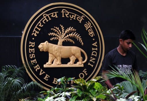 A gardener tends to plants at the Reserve Bank of India headquarters in Mumbai. India's central bank kept its key interest rates unchanged on Tuesday as predicted, but it delivered bleak forecasts for the slowing economy and warned about the country's deficits