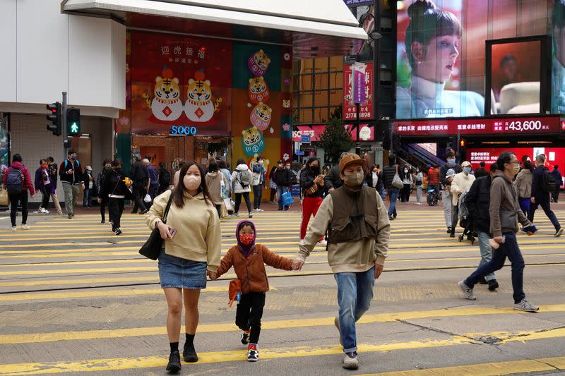 FILE PHOTO: Pedestrians wearing face masks cross a street in Hong Kong