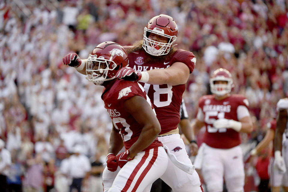 Arkansas running back Dominique Johnson (20) celebrates with Dalton Wagner (78) after scoring a touchdown against Texas during the first half of an NCAA college football game Saturday, Sept. 11, 2021, in Fayetteville, Ark. (AP Photo/Michael Woods)