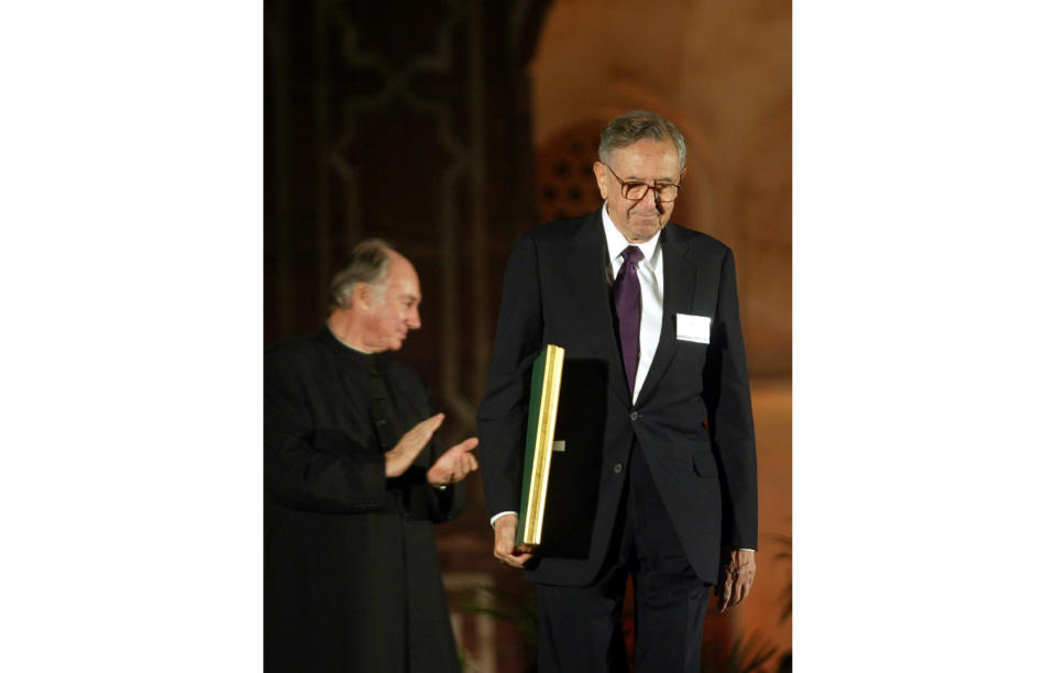 FILE - In this Nov. 27, 2004 file photo, Cesar Pelli of Cesar Pelli and Associates US, right, one of the awardees of the Aga Khan Award for Architecture walks with his award as the Aga Khan, spiritual leader of the Shia Imami Ismaili Muslims, claps during the award ceremony at the gardens of Emperor Humayuns Tomb in New Delhi, India. Pelli, known for designing some of the world’s tallest and most iconic buildings, has died. He was 92. Anibal Bellomio, a senior associate architect at Pelli’s Connecticut studio, confirmed Saturday, July 20, 2019, that Pelli died peacefully on Friday at his home in New Haven. (AP Photo/Manish Swarup)