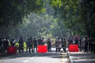 Riot police officers stand guard during a rally against the military coup at the University of Yangon