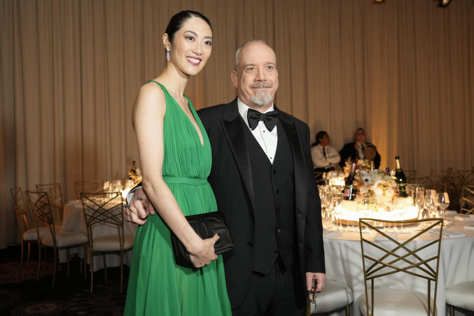 Clara Wong, izquierda, y Paul Giamatti llegan a la 81a edición de los Globos de Oro el domingo 7 de enero de 2024, en el Hotel Beverly Hilton en Beverly Hills, California. (Foto AP/Chris Pizzello)