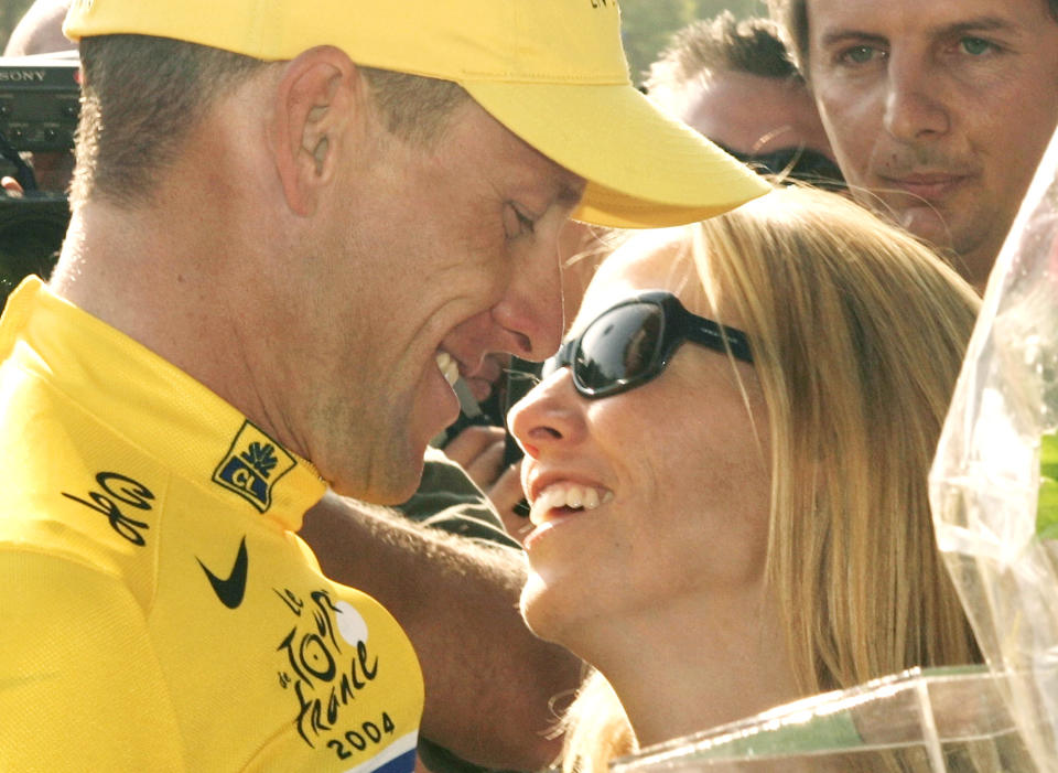 Lance Armstrong en épocas mejores, abrazando a su compañera de entonces Sheryl Crow tras la conquista de su sexto Tour de Francia seguido el 25 de julio del 2004. Armstrong fue suspendido de por vida y despojado de sus siete victorias en el Tour por doparse. (AP Photo/Franck Prevel)