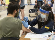 Kent State University student Jarrett Woo gets his Johnson & Johnson COVID-19 vaccination from Kent State nursing student Allie Rodriguez in Kent, Ohio, Thursday, April 8, 2021. U.S. colleges hoping for a return to normalcy next fall are weighing how far they should go in urging students to get the COVID-19 vaccine, including whether they should — or legally can — require it. (AP Photo/Phil Long)