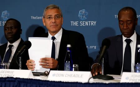 George Clooney (C), with fellow actor Don Cheadle (R) and The Sentry investigative journalist Brian Adeba (L), discuss The Sentry's investigation of the role of national corruption in the ongoing humanitarian crisis in South Sudan during a news conference at the National Press Club in Washington, U.S. September 12, 2016. REUTERS/Jonathan Ernst