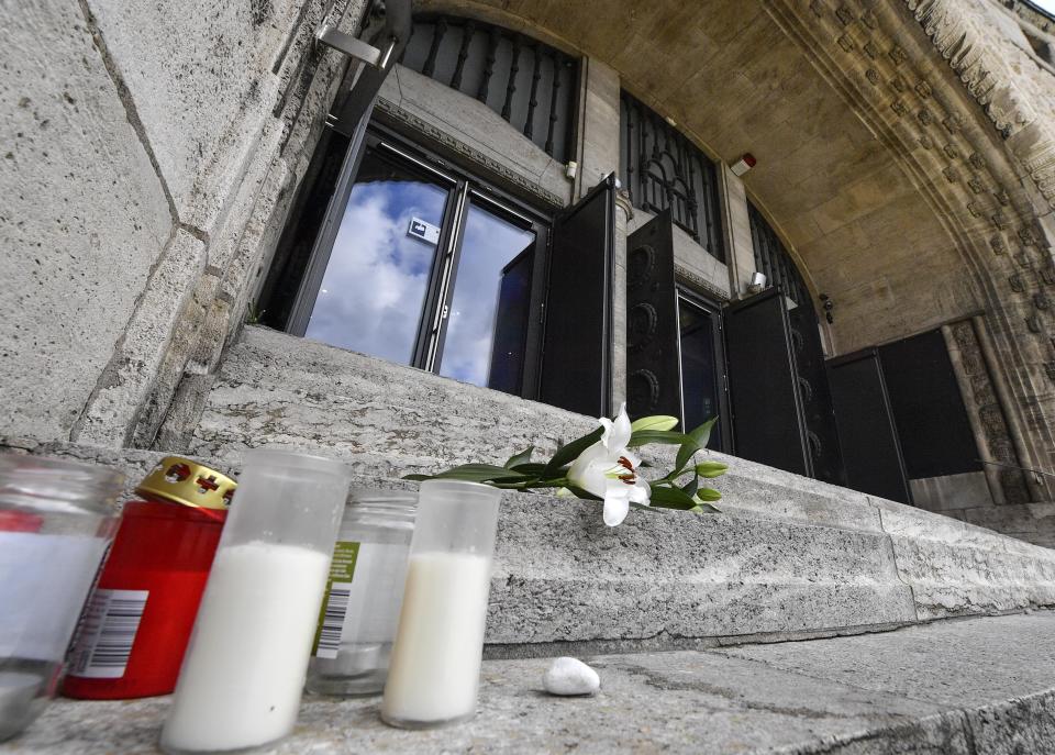 Flowers and candles are set in front of the old synagogue in Essen, Germany, Thursday, Oct. 10, 2019. A heavily armed assailant ranting about Jews tried to force his way into a synagogue in Halle, Germany yesterday, before he killed two people nearby. (AP Photo/Martin Meissner)