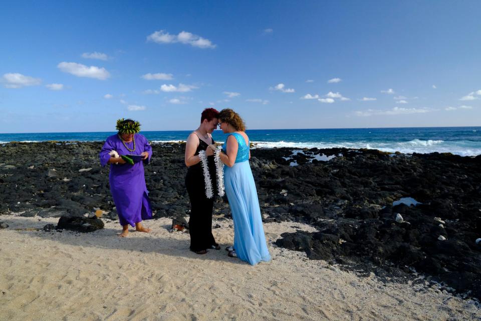 The couple is married on the beach in Hawaii.