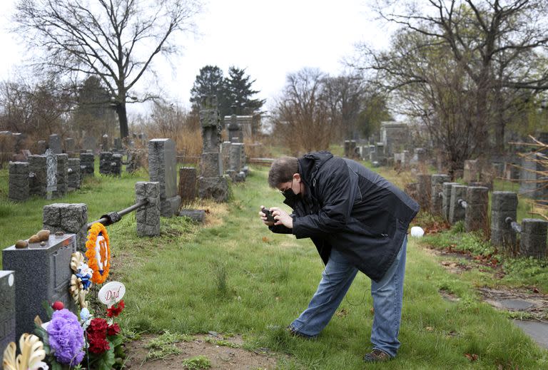Brian Walter toma una fotograf&#xed;a de la l&#xe1;pida de su difunto padre en el cementerio All Faiths en el distrito de Queens de Nueva York