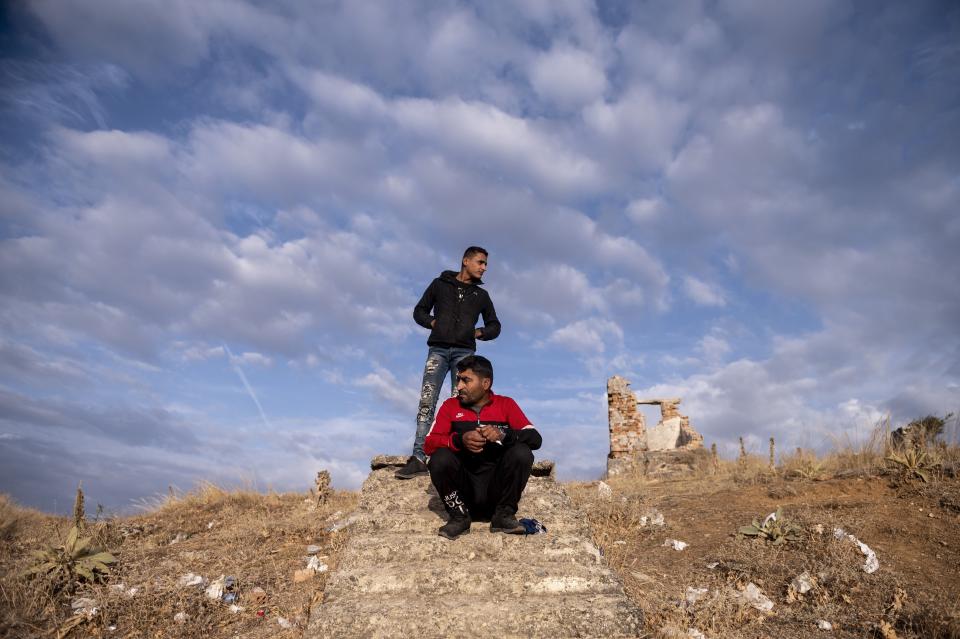 Syrian migrants sit near an abandoned army outpost near Ieropigi village, northern Greece, at the Greek - Albanian border, on Tuesday, Sept. 28, 2021. A relatively smooth section of Greece's rugged border with Albania is turning into a major thoroughfare north for migrants in Greece seeking a better life in Europe's prosperous heartland. (AP Photo/Giannis Papanikos)