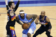 Houston Rockets center DeMarcus Cousins, middle, looks to pass the ball under pressure from Phoenix Suns forward Frank Kaminsky (8) and guard Jevon Carter (4) during the first half of an NBA basketball game Wednesday, Jan. 20, 2021, in Houston. (AP Photo/Michael Wyke)