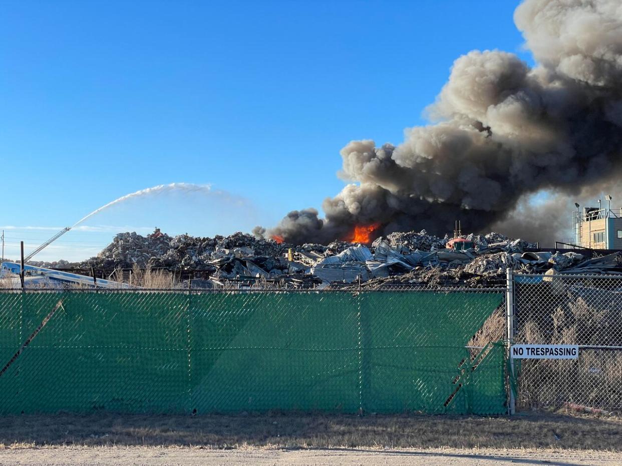 Black smoke fills the sky just north of Regina on Thursday due to a fire at Wheat City Metals. A fire spokesperson says crews could be on scene for a while. (Richard Agecoutay/CBC - image credit)