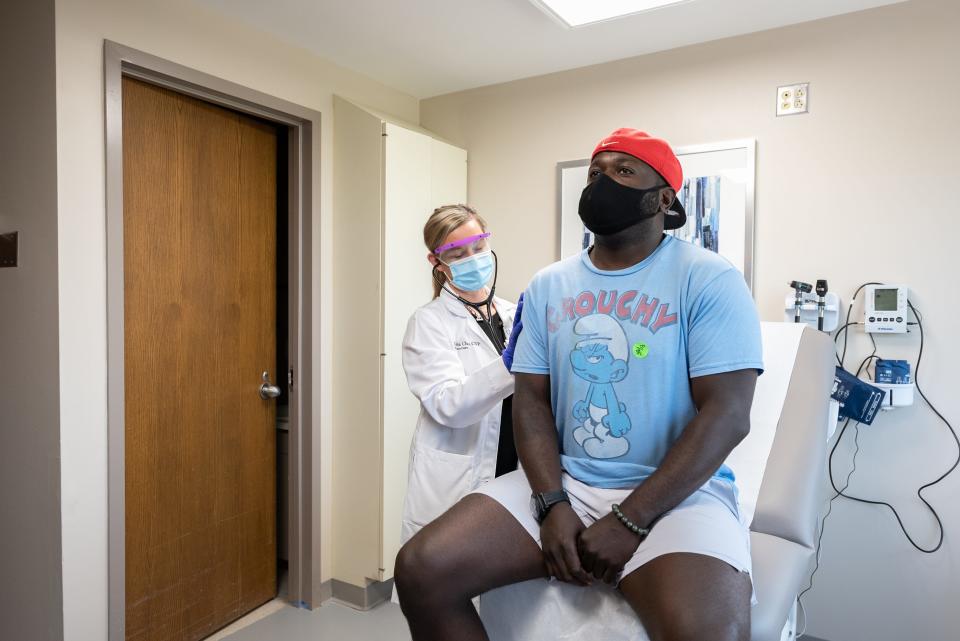 Jarelle Marshall was the first person at UC Health to receive a COVID-19 vaccine as part of a clinical trial. Here, pharmacist Mary Burns administers the shot.