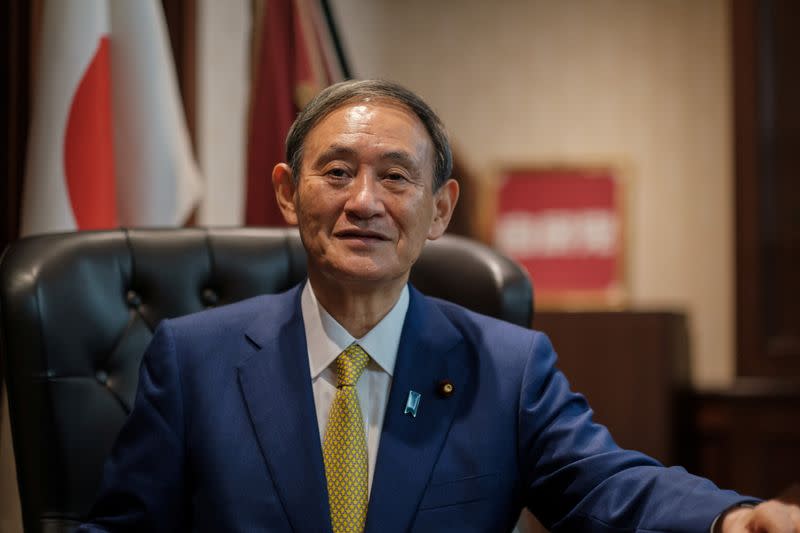 Yoshihide Suga poses for a picture following a press conference in Tokyo