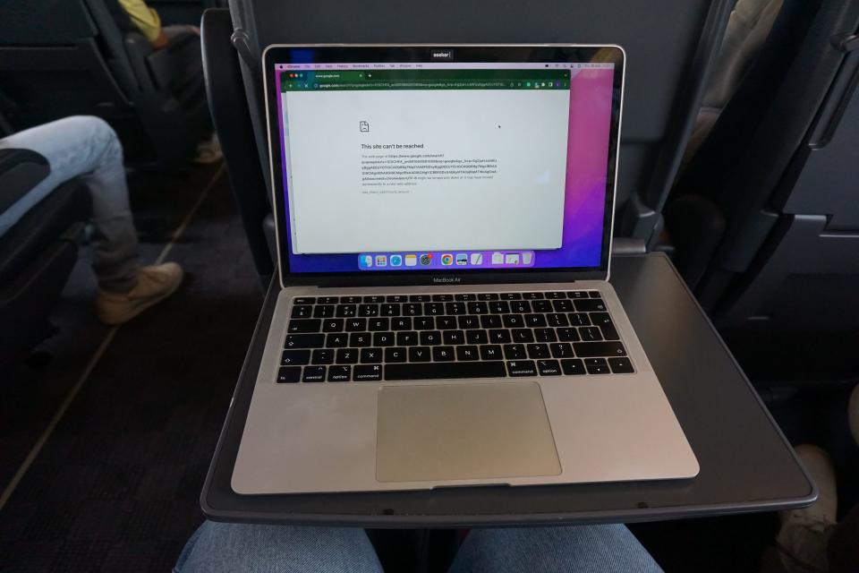 A MacBook on a tray in a train.