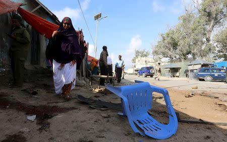 A Somali woman walks past the scene of an explosion following an attack in Somalia's capital Mogadishu, March 9, 2016. REUTERS/Feisal Omar