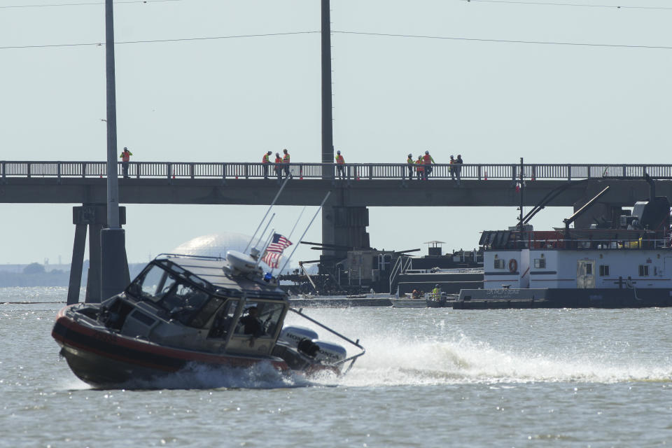 Officials respond after the Pelican Island Bridge was closed when a passing barge struck one of its supports, Wednesday, May 15, 2024, in Galveston, Texas. A barge slammed into a bridge pillar on Wednesday, spilling oil into surrounding waters and closing the only road to a smaller and separate island that is home to a university, officials said. (Jon Shapley/Houston Chronicle via AP)