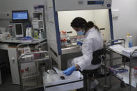 Seminar Kibir, health lab technician prepares chemicals to process analysis of some nasal swab samples to test for COVID-19 at the Hospital of Argenteuil, north of Paris, Friday Sept. 25, 2020. France's health agency announced Thursday evening that the country has had 52 new deaths and has detected over 16,000 new cases of coronavirus in 24 hours. (AP Photo/Francois Mori)