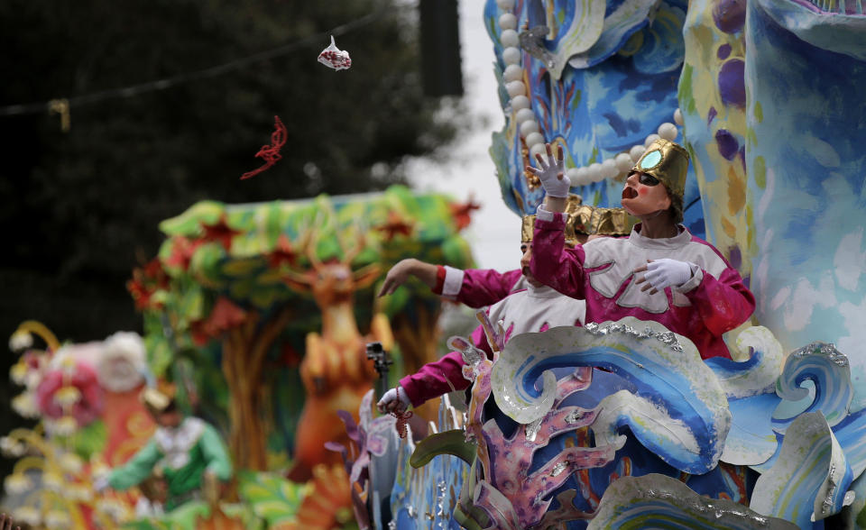 A float rider throws beads from his float during the Krewe of Proteus Mardi Gras parade in New Orleans, Monday, Feb. 16, 2015. 